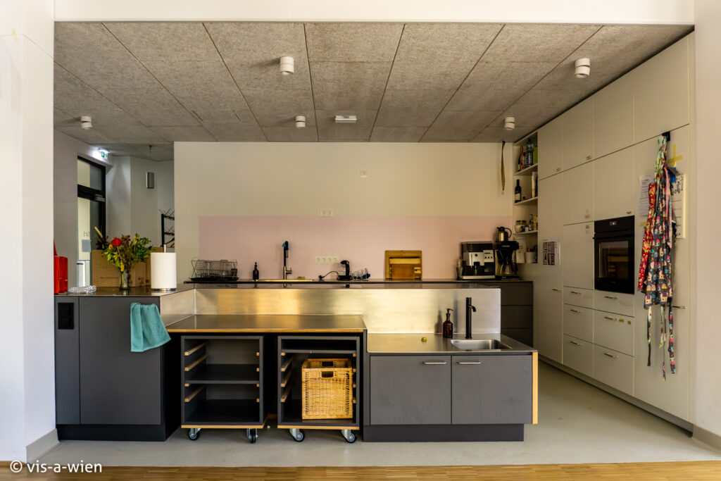 Innenansicht Grätzlküche mit zwei Küchenzeilen mit einem niedrigeren Arbeitsplatz für Personen im Rollstuhl und Kinder